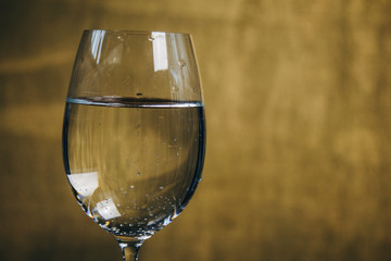 cropped glass of white wine on a rustic wooden brown background. rest, holiday, party. alcoholic drink closeup. copy space