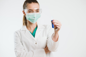Young nurse holding a test tube, testin liquid.