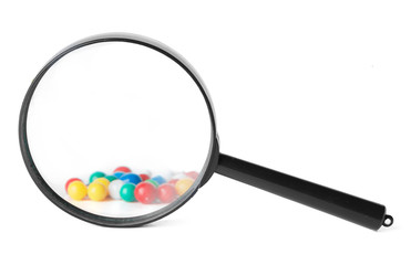 Magnifying glass looking at closeup of push pin tacks