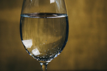 cropped glass of white wine on a rustic wooden brown background. rest, holiday, party. alcoholic drink closeup. copy space