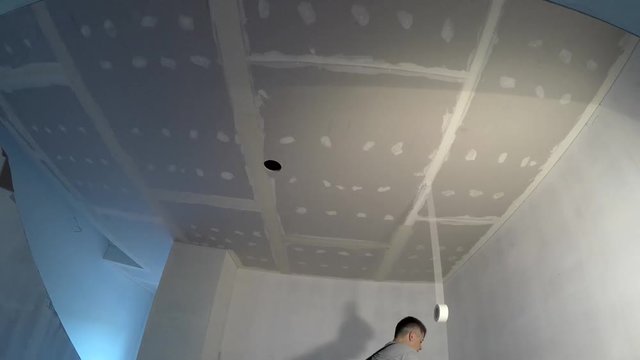 builder plaster ceiling plasterboard joints. Man showing finger up. Timelapse