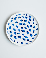New luxury elegance cutlery view from above on a isolated white background. Top view. Porcelain saucer with blue points. Trendy plate. Flat lay view.
