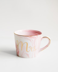 New pink mug with marble texture and mr inscription on isolated white background.