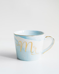 New blue mug with marble texture and mr inscription on isolated white background.