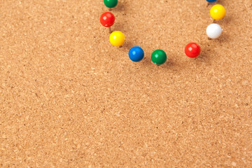 Group of thumbtacks pinned on corkboard
