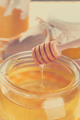 Honey background. Sweet honey in glass jar on wooden background.