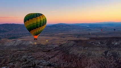 Fototapeta na wymiar Colorful hot air balloons soaring over the volcanic valley at sunrise. Cappadocia,Turkey, autumn.