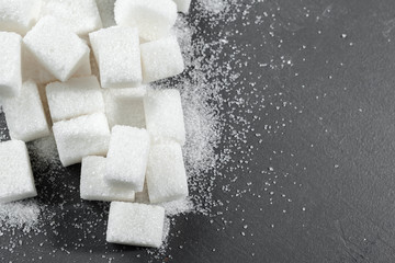 White sugar cubes over black background close up