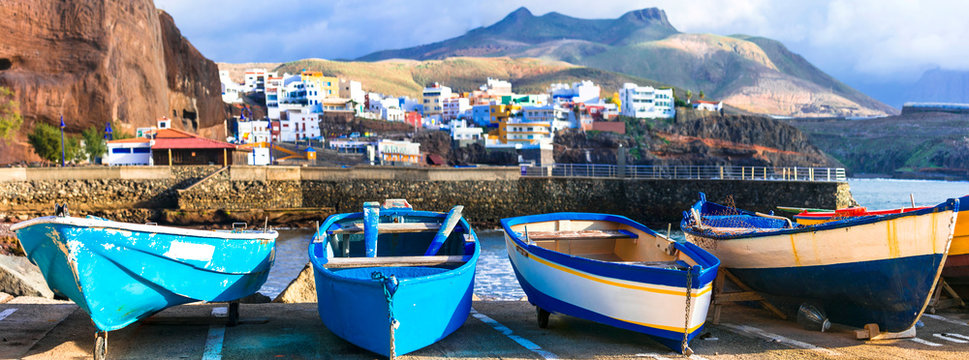 Spain Gran Canaria Puerto de Sardina high resolution 12K panorama with fishing boats. Authentic colorful coastal village on volcanic black sand beach. Scenic Canary Islands travel wall art