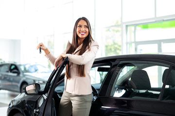 Fototapeta na wymiar Young happy woman near the car with keys in hand - buying new car