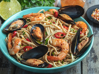 Noodles with shrimp and mussels , spice , on the plate. Closeup. Chinese/Japanese/Asian noodles
