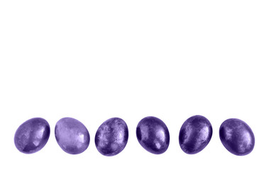 Ultraviolet Easter eggs in a row on isolated white background. Copy space.