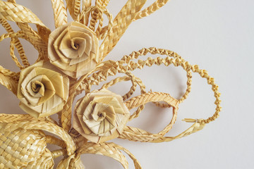 Decoration of straw on a white background. Branch with flowers. Decor. Fragment. The products are made of straw 