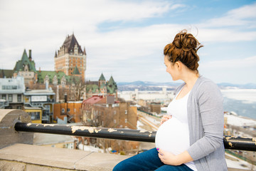 Fototapeta na wymiar Pregnant girl outside on a city background