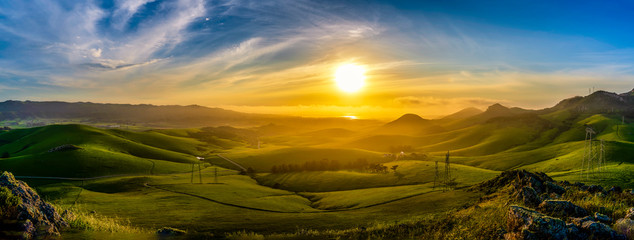 Fototapeta na wymiar Panorama of Setting Sun on Rolling Green Hills