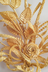Decoration of straw on a white background. Branch with flowers. Decor. Fragment. The products are made of straw 