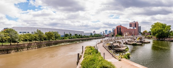 Fototapeta na wymiar Bow Creek (tidal) (far left) meets the Limehouse Cut (canal, right), at Bow Locks on the Lee Navigation (centre); with a view of London's
