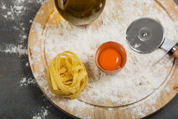 Italian raw homemade pasta tagliatelle at concrete table