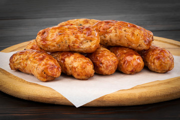 Tasty grilled sausage on the wooden background