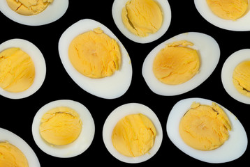 Sliced boiled chicken eggs on a dark background