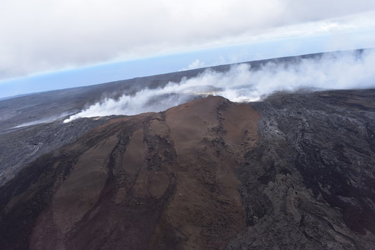 Arial View of Mauna Loa Volcano Crater Hawaii Smoke billowing from the crater and fissures as magma leaks to the surface