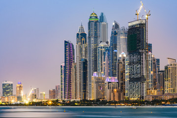 Stunning view of the illuminated Dubai Marina skyline during sunset. Picture taken from the  Palm Jumeirah artificial archipelago. Dubai Marina, Dubai, United Arab Emirates.