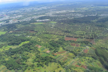 Fototapeta premium Arial View of Hawaiian Rainforest and waterfalls amid a dense tropical rainforest with rivers and valleys zig zagging across the land