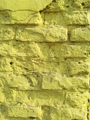 Textured abstract background old yellow brick wall dirty vintage sunny day