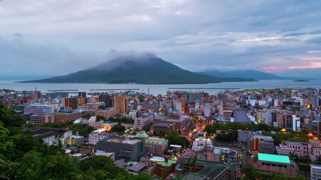 Kagoshima, Japan. View of mountain Sakurajima an active volcano. Aerial view of Kagoshima city in Japan at sunrise. Time-lapse with volcano eruption in the morning