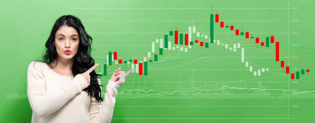 Stock market candle chart with young woman pointing on a green background