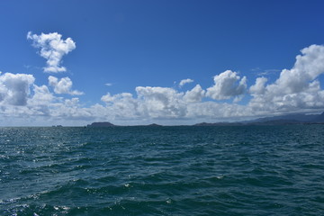 Mountains along the Pacific Ocean. Dense jungle growing around and up the steep slopes under a beautiful blue sky