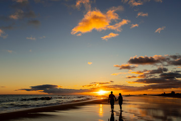 happy couple walking on seashore on a beach vacation or honeymoon trip - 260554755