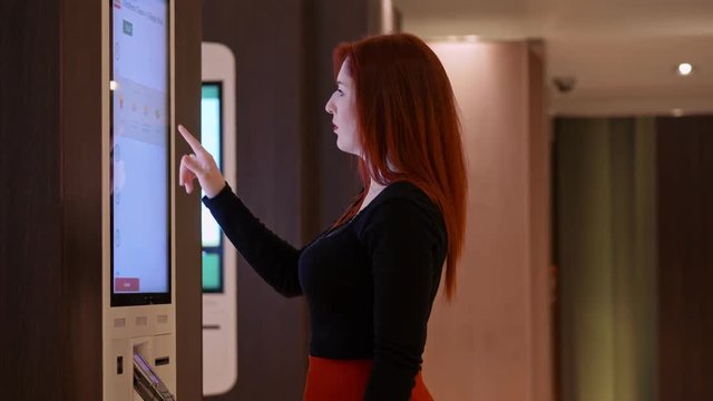 beautiful and charming woman choosing some food at the vending machine