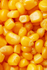 Golden canned corn, as distributed on a plane background and texture of popcorn. Before watching a movie top view. Close-up