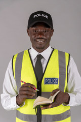 Salisbury, Wiltshire, England, UK. April 2019. A British police officer wearing a cap and reflective uniform jacket taking notes.