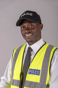 Salisbury, Wiltshire, England, UK, April 2019. Portrait of a smiling, police officer wearing a cap and reflective uniform jacket.