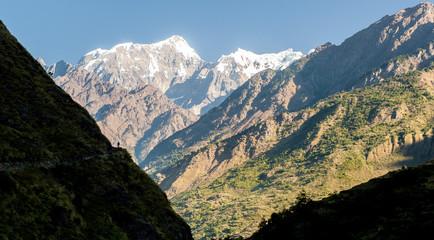 Fototapeta na wymiar A trekker on Manaslu circuit with viiew of snow covered Mount Manaslu (8 156 meters). Himalayas, sunny day at Manaslu Glacier in Gorkha District in northern-central Nepal