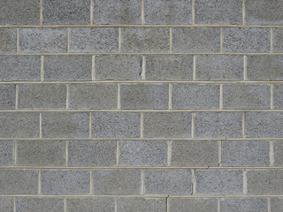 Gray brick wall of a fence folded from large stones background