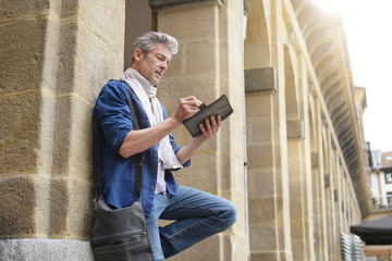 Mature artist sketching in historical town