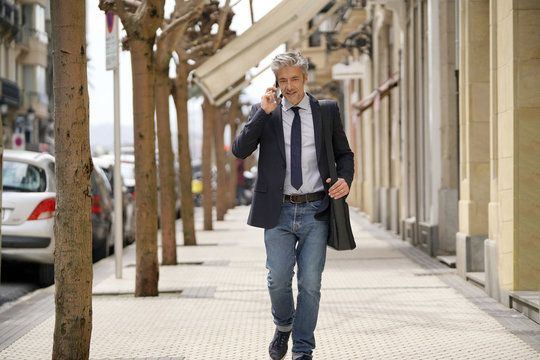 Businessman Commuting On Foot With Cellphone