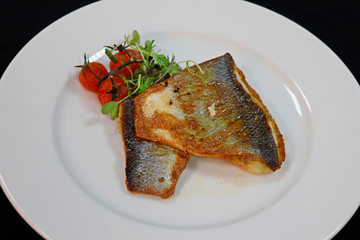 pan fried sea bass in a white plate