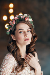 Beauty portrait of young woman with wreath of flowers in her hair