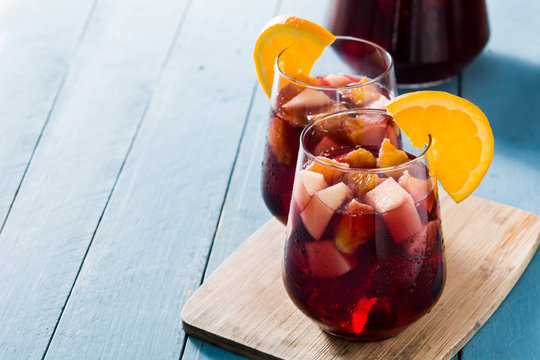 Red wine sangria in glass on blue wooden table. Copyspace