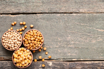 Roasted and dry chickpeas in bowls on grey wooden table