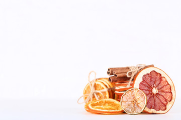 Dried citrus fruits with cinnamon on white background