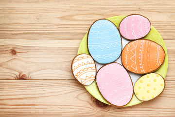 Easter gingerbread cookies in plate on brown wooden table