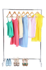 Fashion dresses hanging on wooden hanger with high heeled shoes