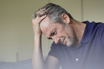 Mature man with bad headache at home