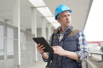 Lead architect checking work sight with tablet