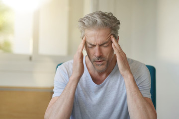 Mature man with bad headache at home